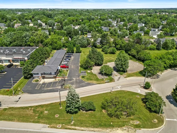 an aerial view of residential houses with outdoor space and trees