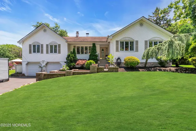 a front view of a house with a garden and plants