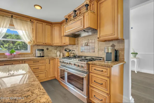 a kitchen with stainless steel appliances granite countertop a stove a sink and a refrigerator