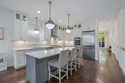 a kitchen with kitchen island granite countertop a sink a center island and stainless steel appliances