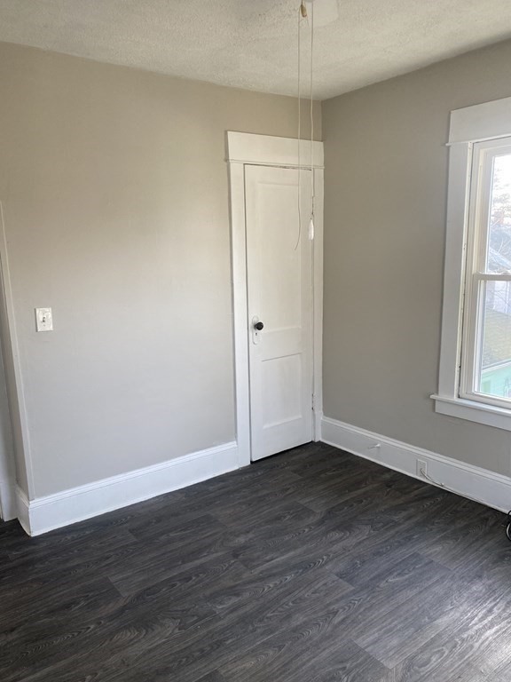 76-78 Ardmore Street Springfield, MA 01104 - Photo 17 of 20 a view of an empty room with wooden floor and a window