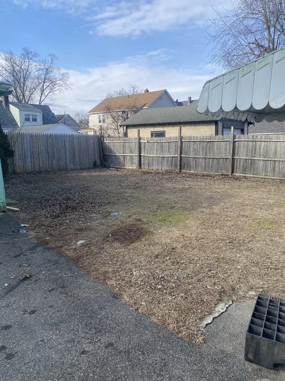 76-78 Ardmore Street Springfield, MA 01104 - Photo 5 of 20 a view of a backyard with a barbeque and wooden fence
