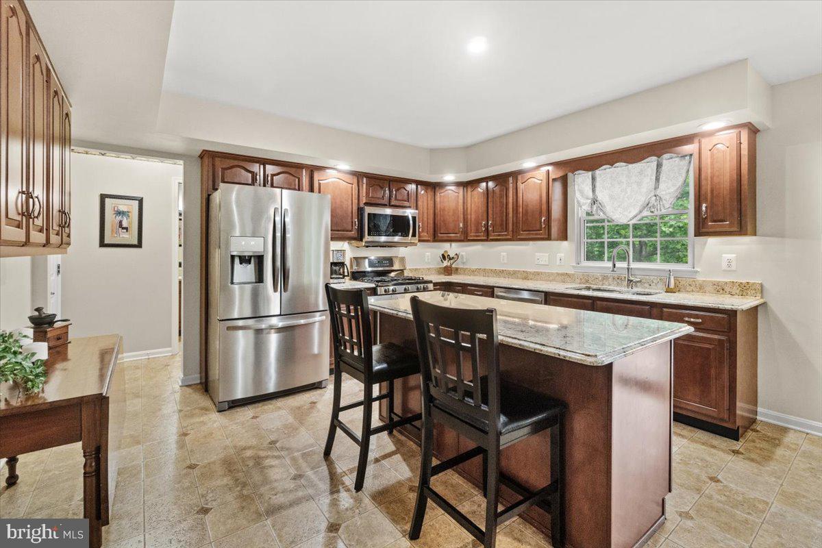 2218 West Greenleaf Drive Frederick, MD 21702 - Photo 11 of 46 a kitchen with stainless steel appliances granite countertop a stove a refrigerator a sink a stove and white cabinets with wooden floor