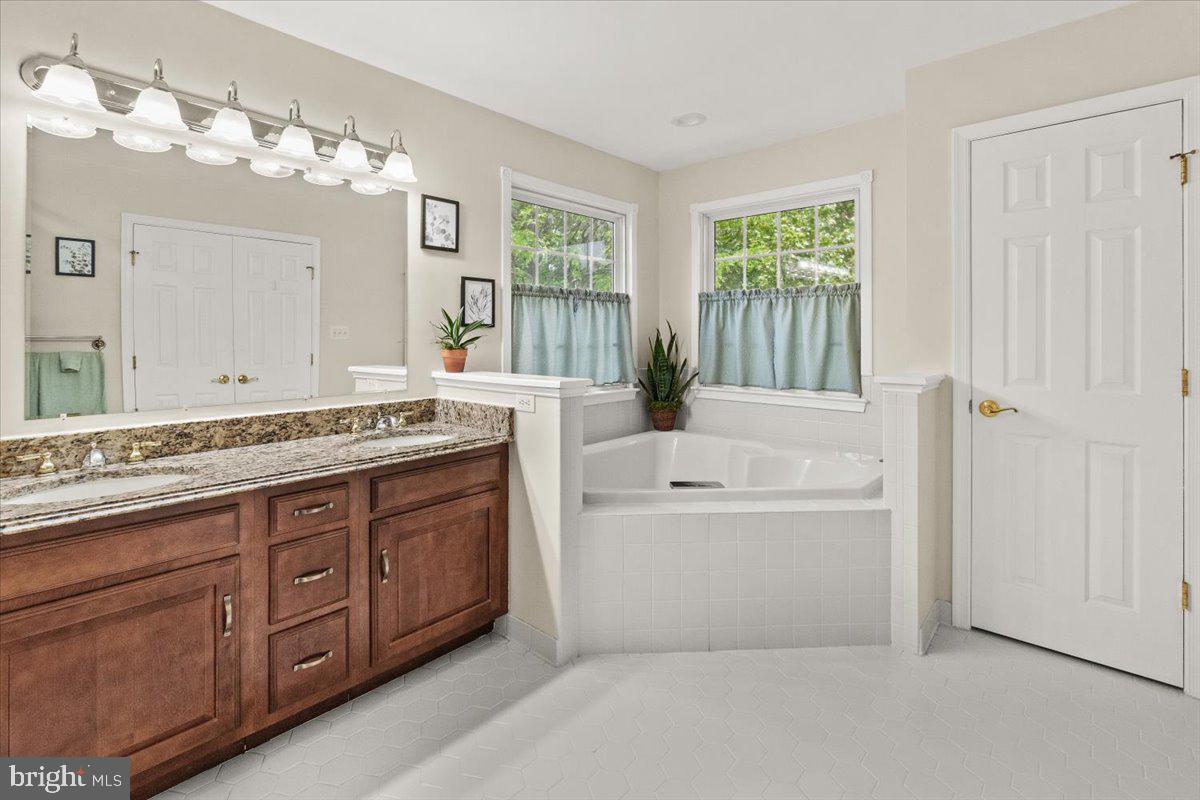 2218 West Greenleaf Drive Frederick, MD 21702 - Photo 32 of 46 a spacious bathroom with a granite countertop tub sink and mirror