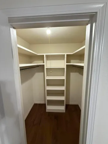 a view of walk in closet with empty racks