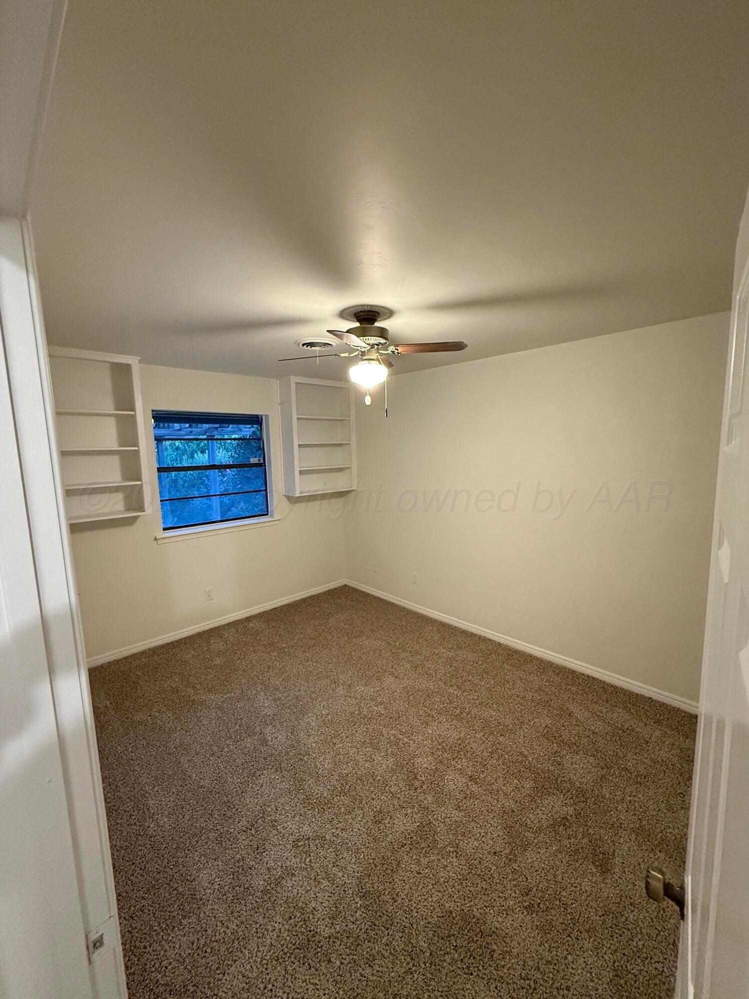 7606 Canode Drive Amarillo, TX 79121 - Photo 15 of 20 an empty room with windows and ceiling fan