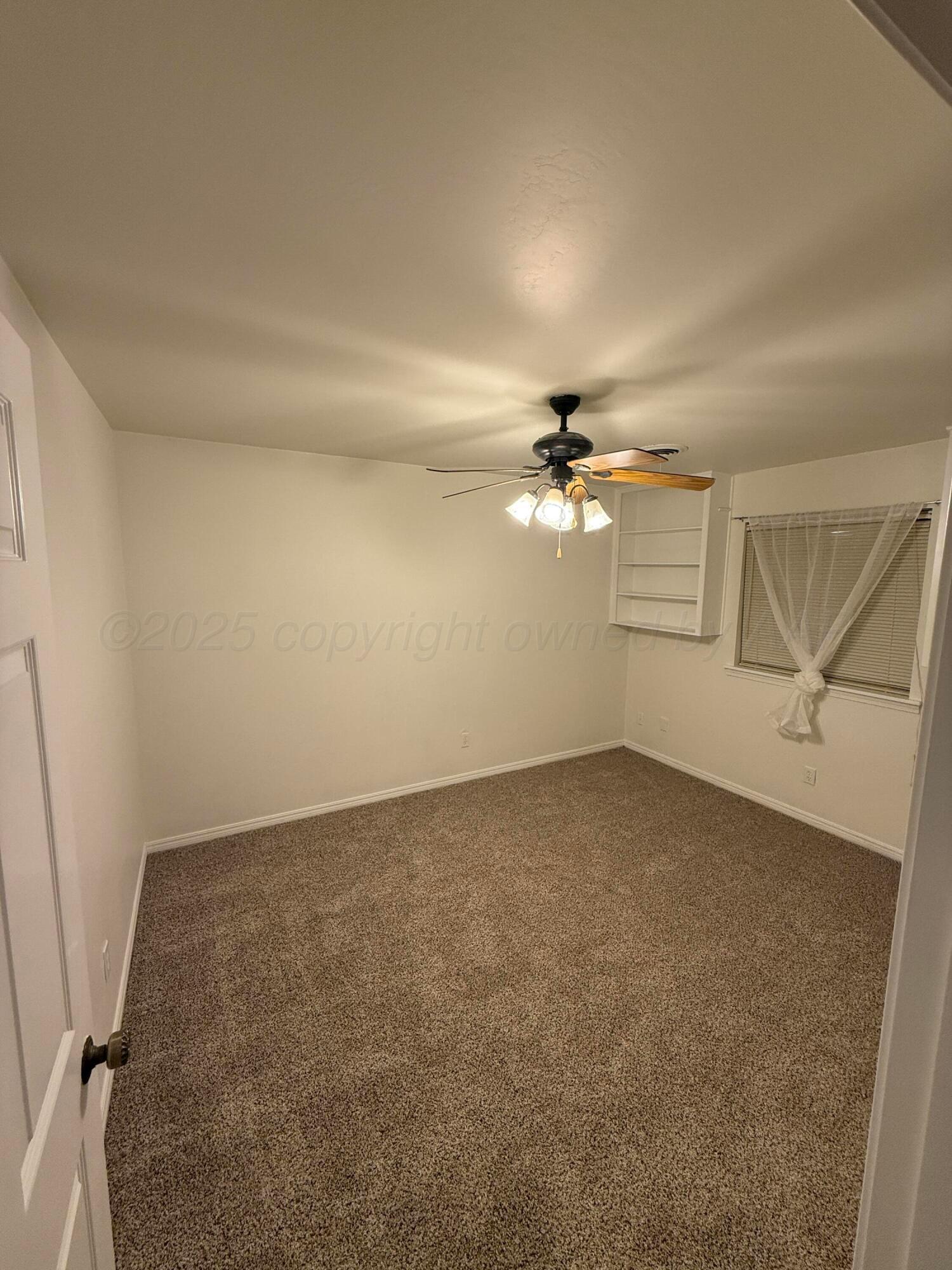 7606 Canode Drive Amarillo, TX 79121 - Photo 17 of 20 an empty room with chandelier fan and windows