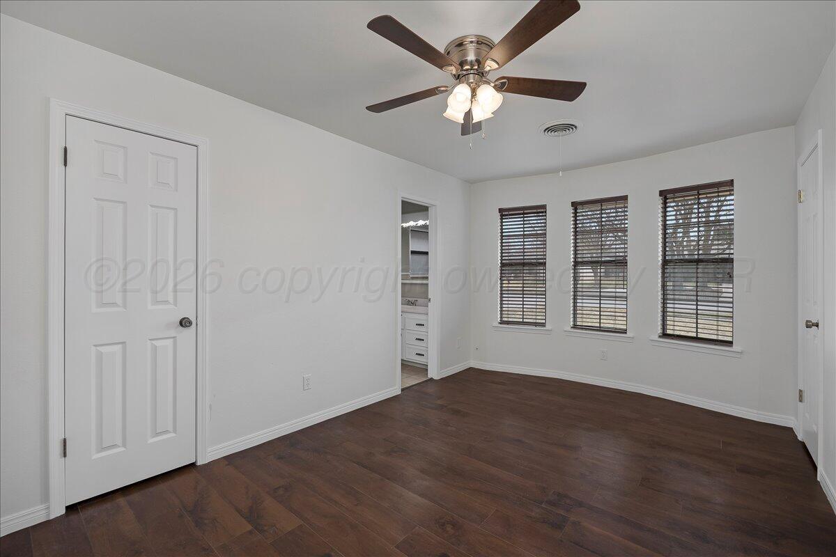 7606 Canode Drive Amarillo, TX 79121 - Photo 17 of 30 a view of an empty room with a window and wooden floor