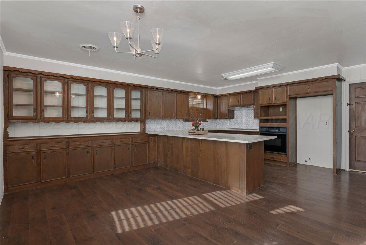 7606 Canode Drive Amarillo, TX 79121 - Photo 7 of 30 a kitchen with stainless steel appliances granite countertop a sink cabinets and wooden floor