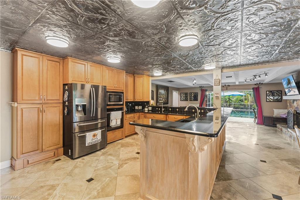 8012 Kansas Road Fort Myers, FL 33967 - Photo 11 of 44 Kitchen featuring a kitchen bar, stainless steel appliances, sink, kitchen peninsula, and rail lighting