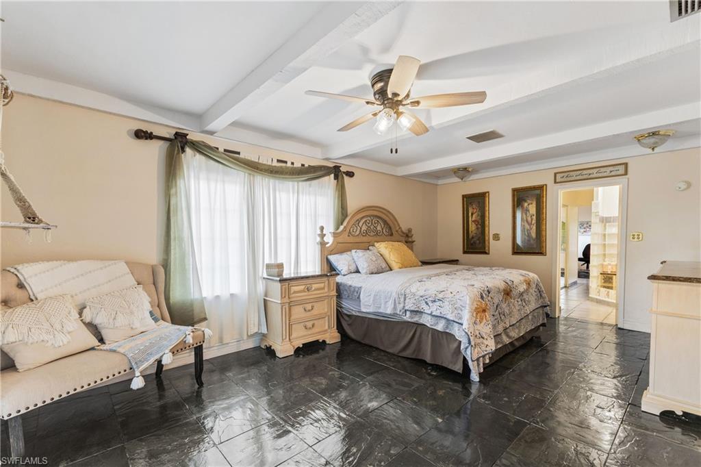8012 Kansas Road Fort Myers, FL 33967 - Photo 16 of 44 Bedroom featuring ceiling fan, beam ceiling, and ensuite bath