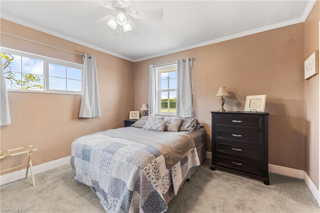 8012 Kansas Road Fort Myers, FL 33967 - Photo 23 of 44 Carpeted bedroom featuring ceiling fan and ornamental molding