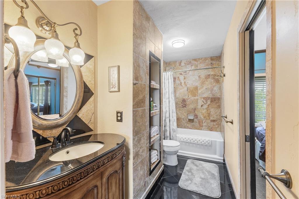 8012 Kansas Road Fort Myers, FL 33967 - Photo 24 of 44 Full bathroom featuring shower / bath combo, tile patterned flooring, toilet, and vanity