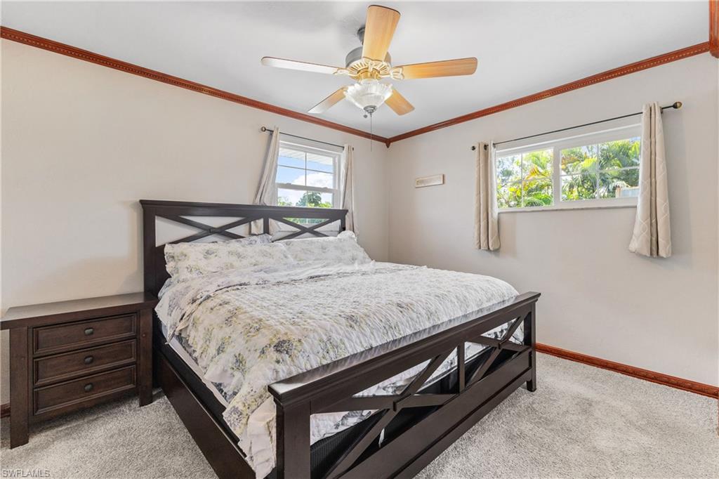 8012 Kansas Road Fort Myers, FL 33967 - Photo 27 of 44 Carpeted bedroom with multiple windows, ceiling fan, and ornamental molding