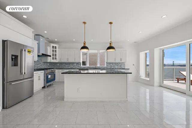 a large kitchen with granite countertop white cabinets and white appliances