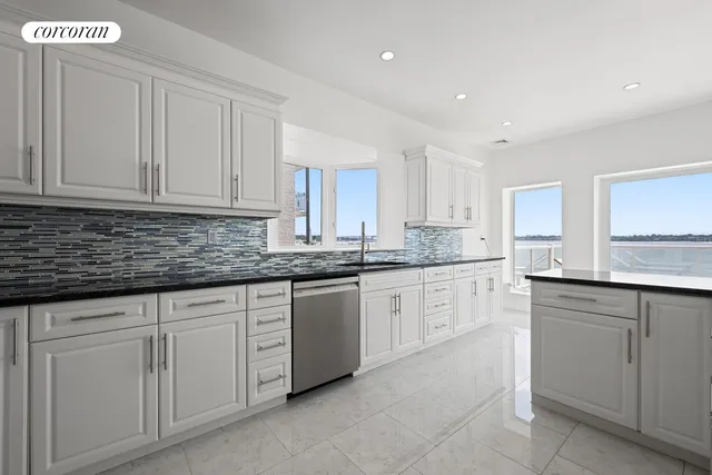 a kitchen with granite countertop white cabinets and stainless steel appliances