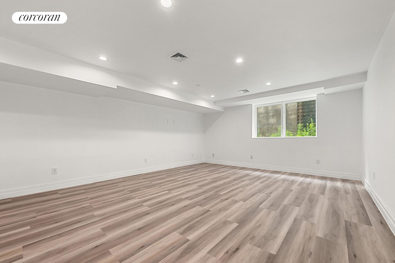 4 Angelas Place Bronx, NY 10026 - Photo 52 of 68 a view of an empty room with wooden floor and a window