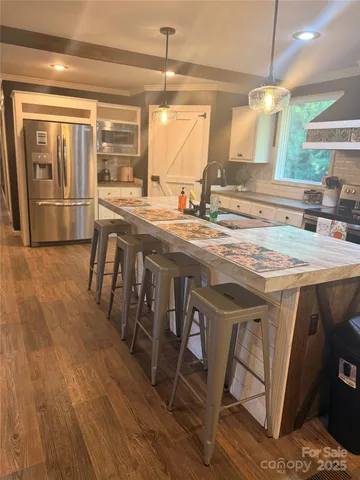 a kitchen with stainless steel appliances granite countertop a stove and white cabinets