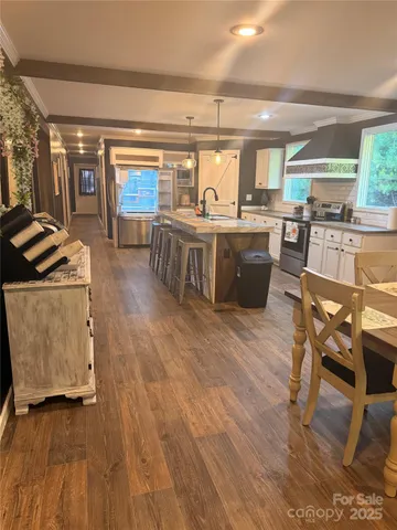 a kitchen with stainless steel appliances granite countertop a stove and a wooden floors