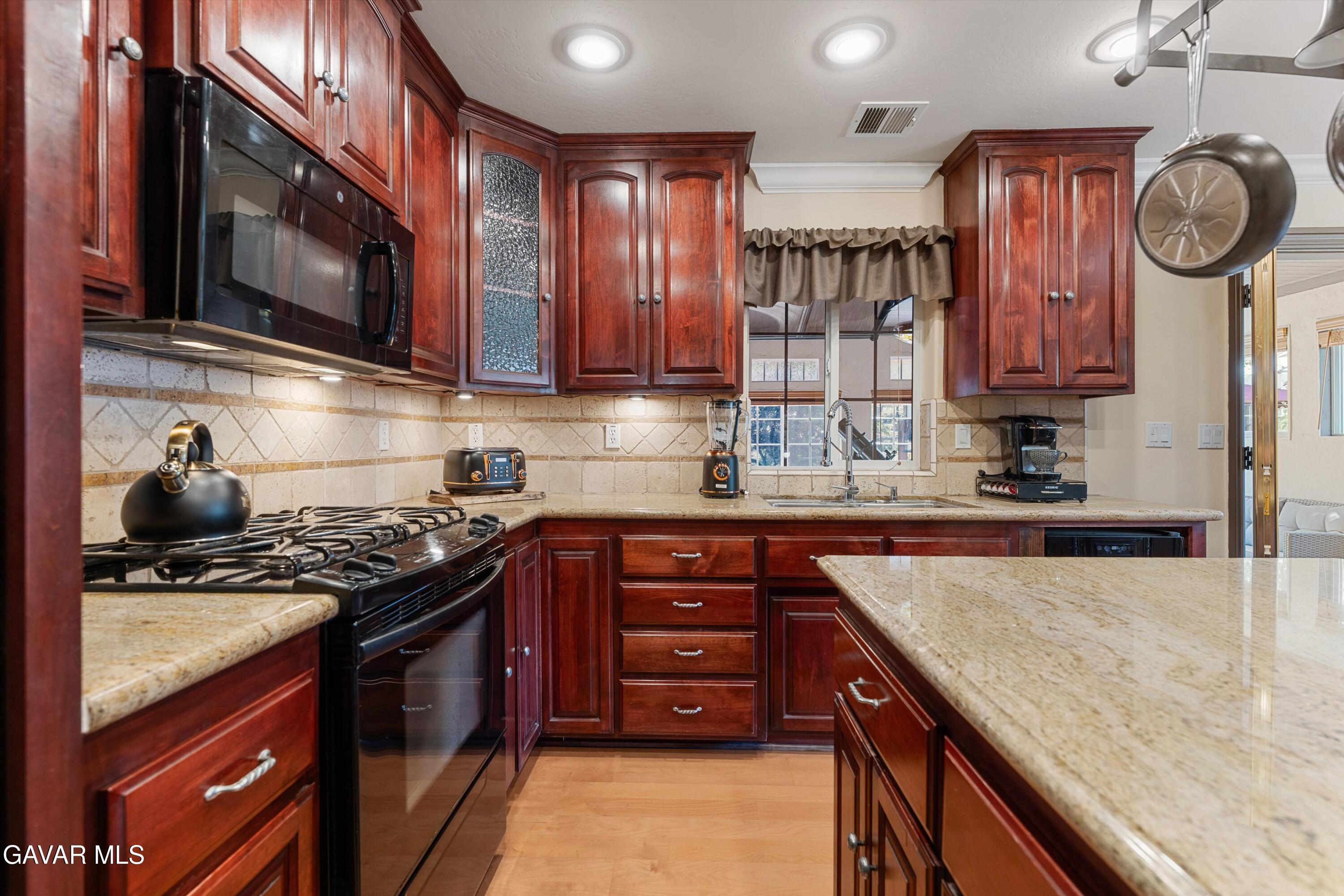 18250 Arosa Road Tehachapi, CA 93561 - Photo 11 of 71 a kitchen with stainless steel appliances granite countertop a sink stove and microwave