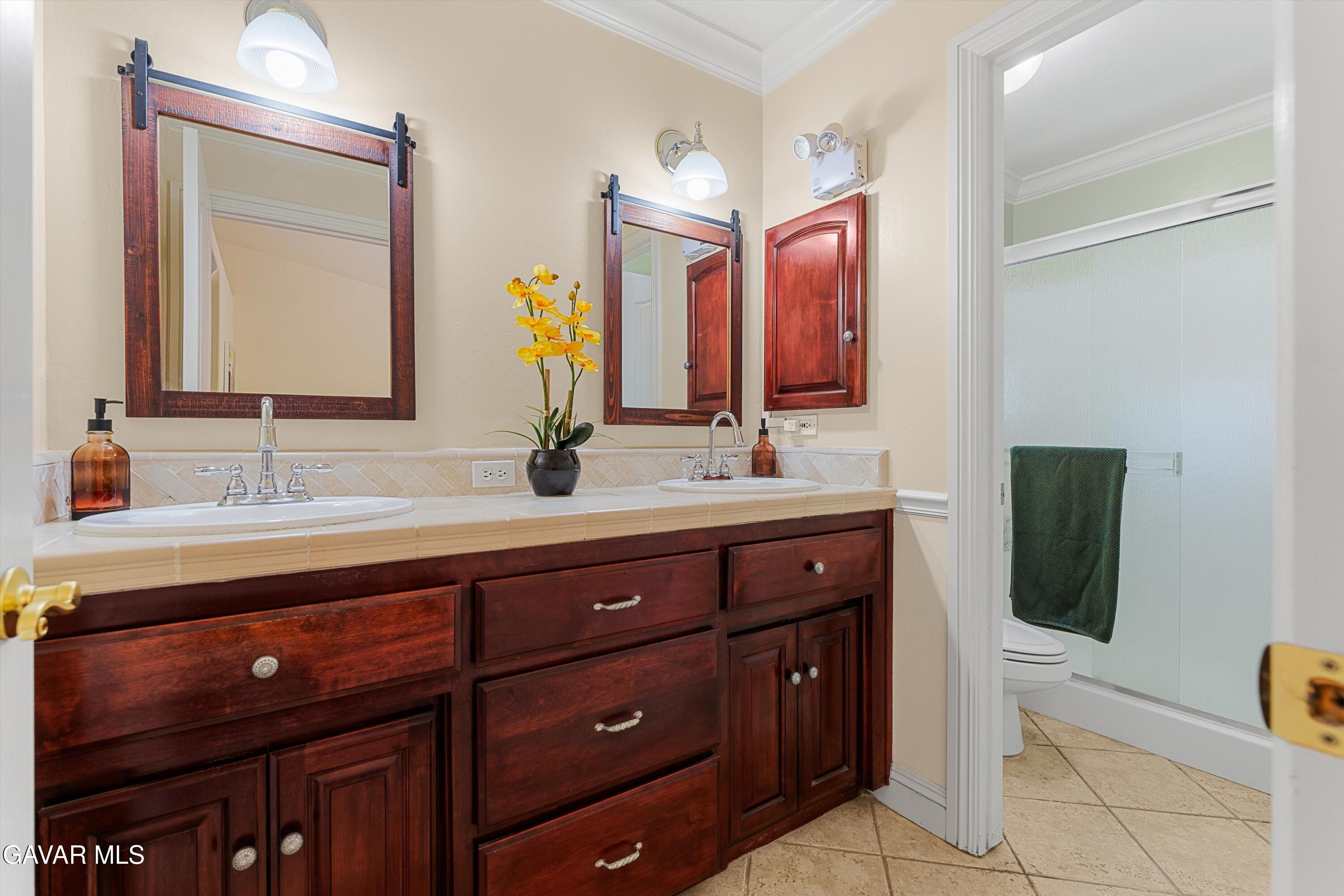 18250 Arosa Road Tehachapi, CA 93561 - Photo 26 of 71 a bathroom with a double vanity sink and a mirror