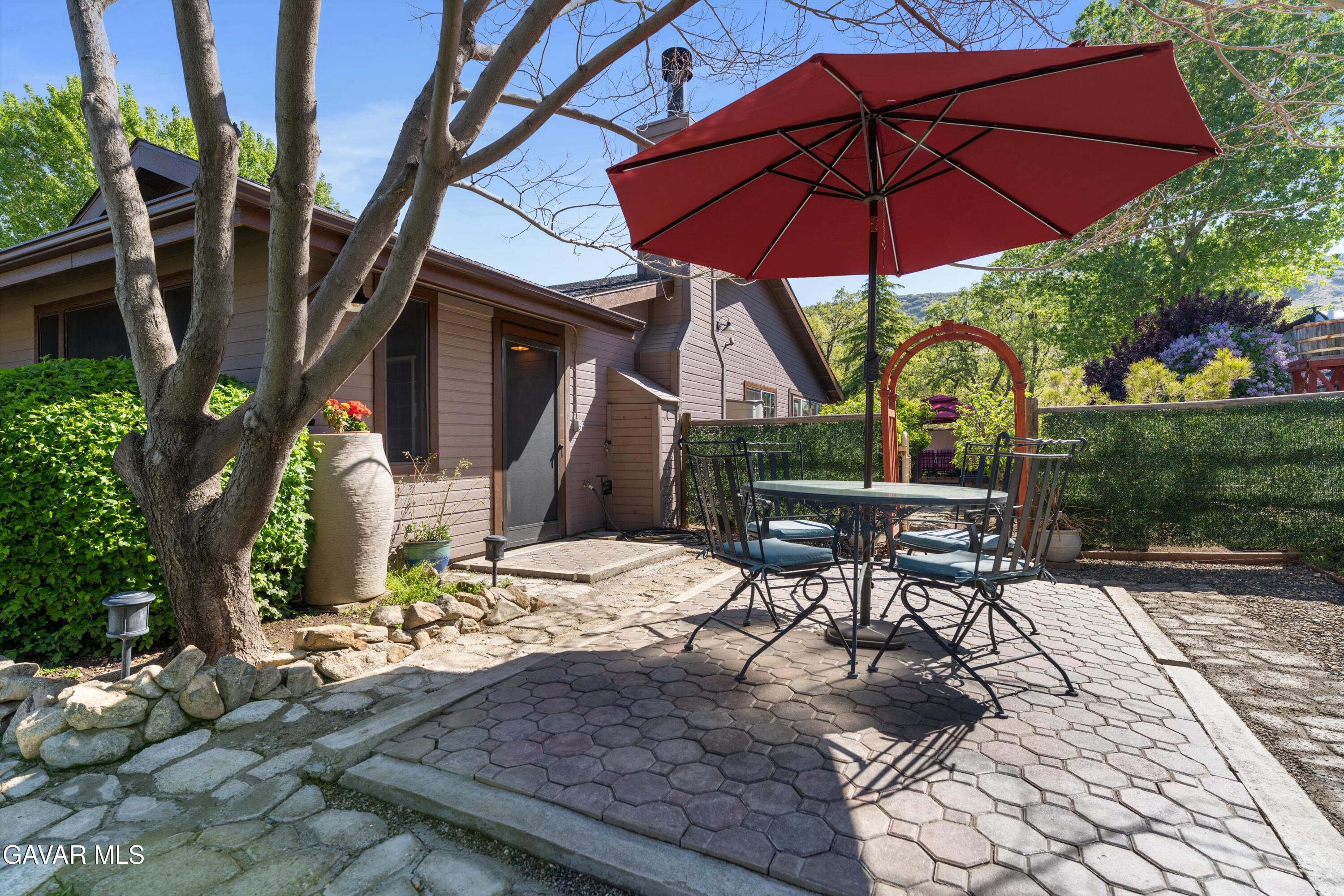 18250 Arosa Road Tehachapi, CA 93561 - Photo 41 of 71 a patio with a table and chairs under an umbrella