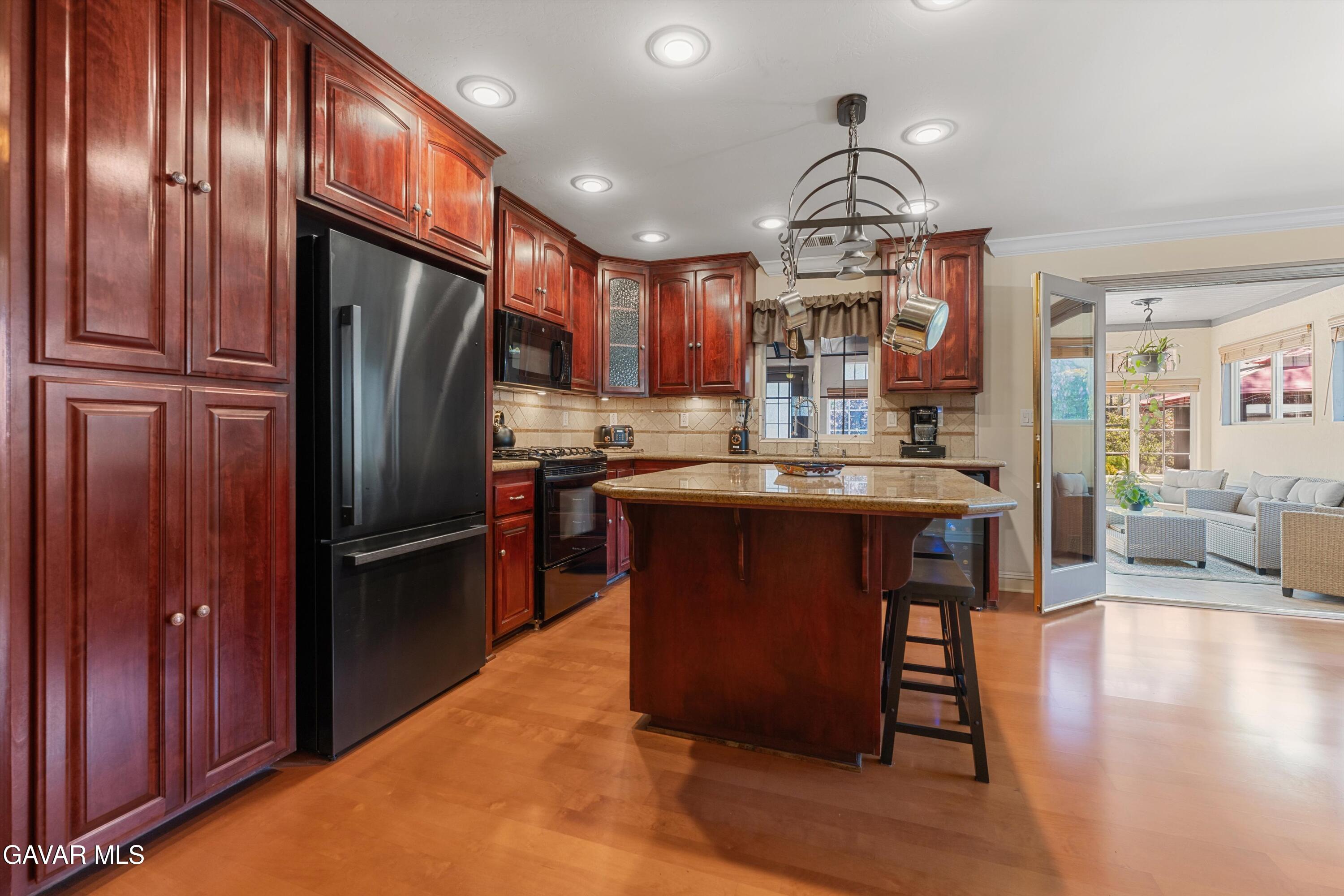 18250 Arosa Road Tehachapi, CA 93561 - Photo 9 of 71 a kitchen with stainless steel appliances granite countertop a refrigerator a stove and a wooden floors