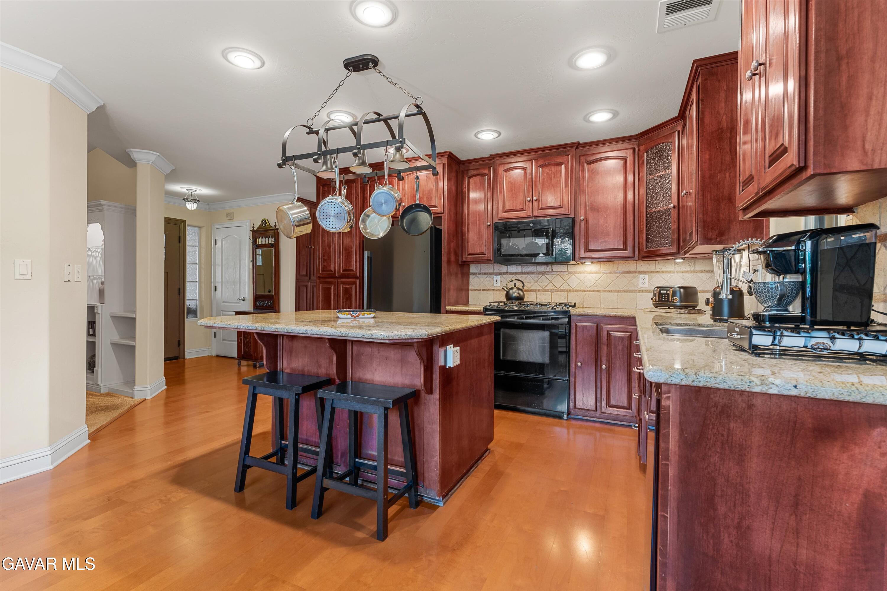 18250 Arosa Road Tehachapi, CA 93561 - Photo 10 of 71 a kitchen with stainless steel appliances granite countertop a sink a stove and a wooden floors