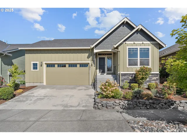 a front view of a house with a yard and potted plants