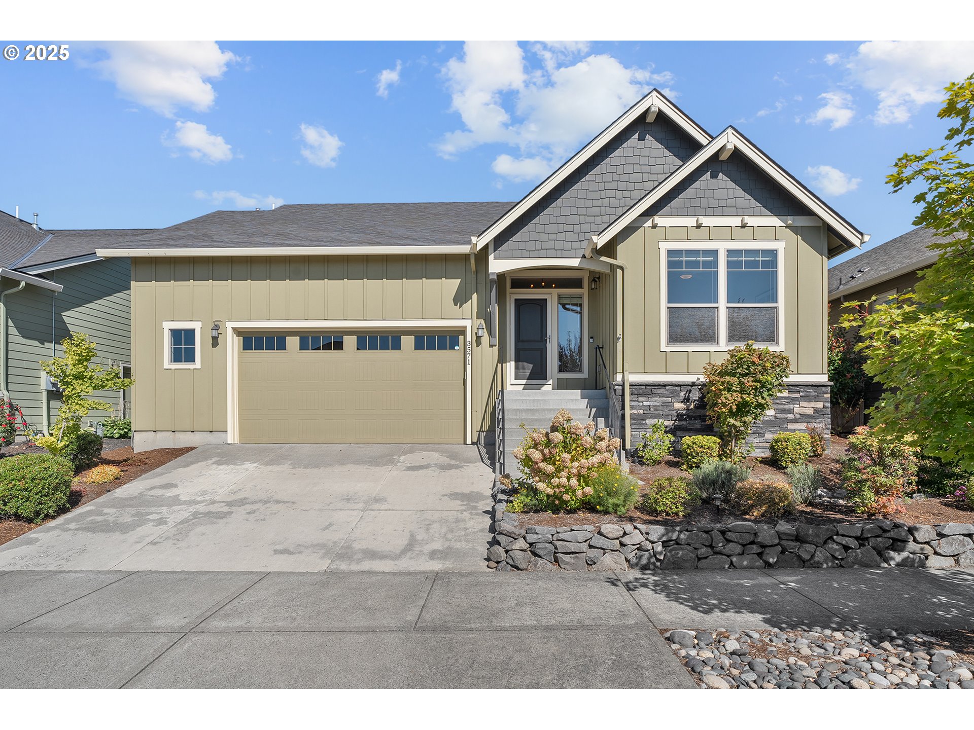 a front view of a house with a yard and potted plants
