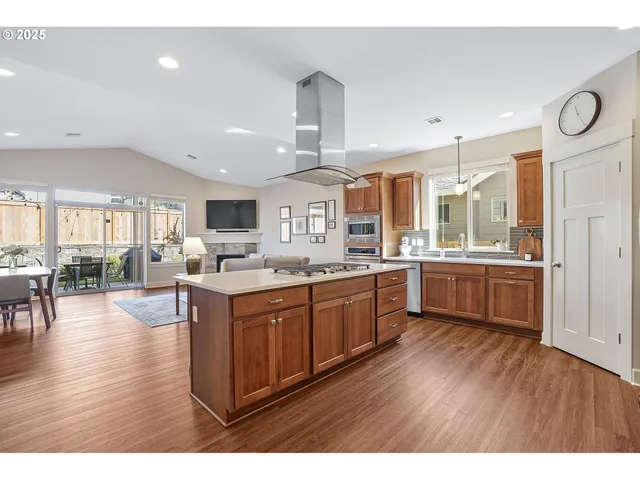 a kitchen with stainless steel appliances granite countertop wooden floors and view living room