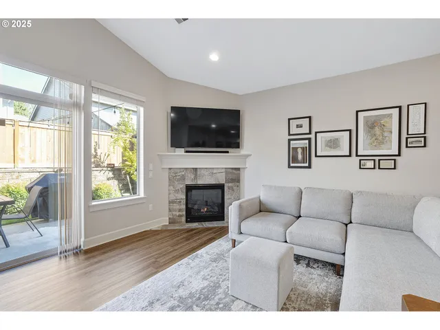 a living room with furniture a flat screen tv and a fireplace