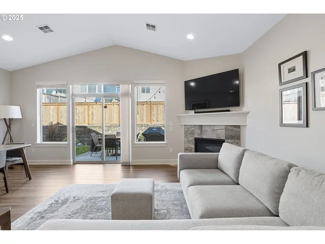 a living room with furniture a flat screen tv and a fireplace