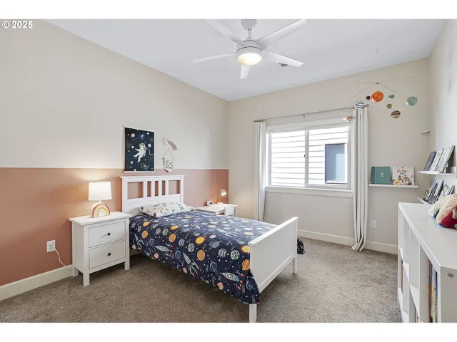 a bedroom with a bed next to a window with a dresser