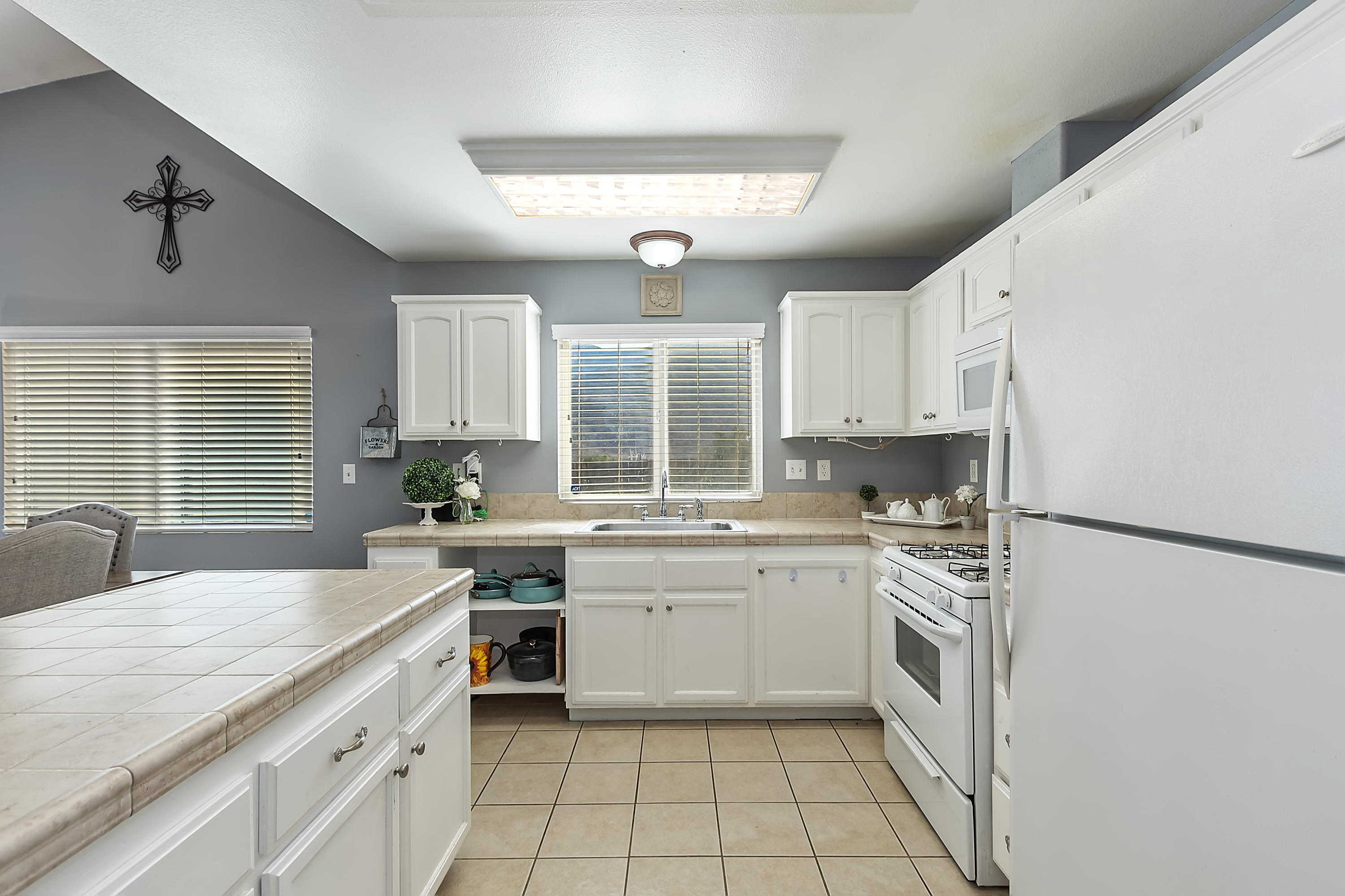 13140 Zane Way Whitewater, CA 92282 - Photo 12 of 25 a kitchen with white cabinets and white appliances
