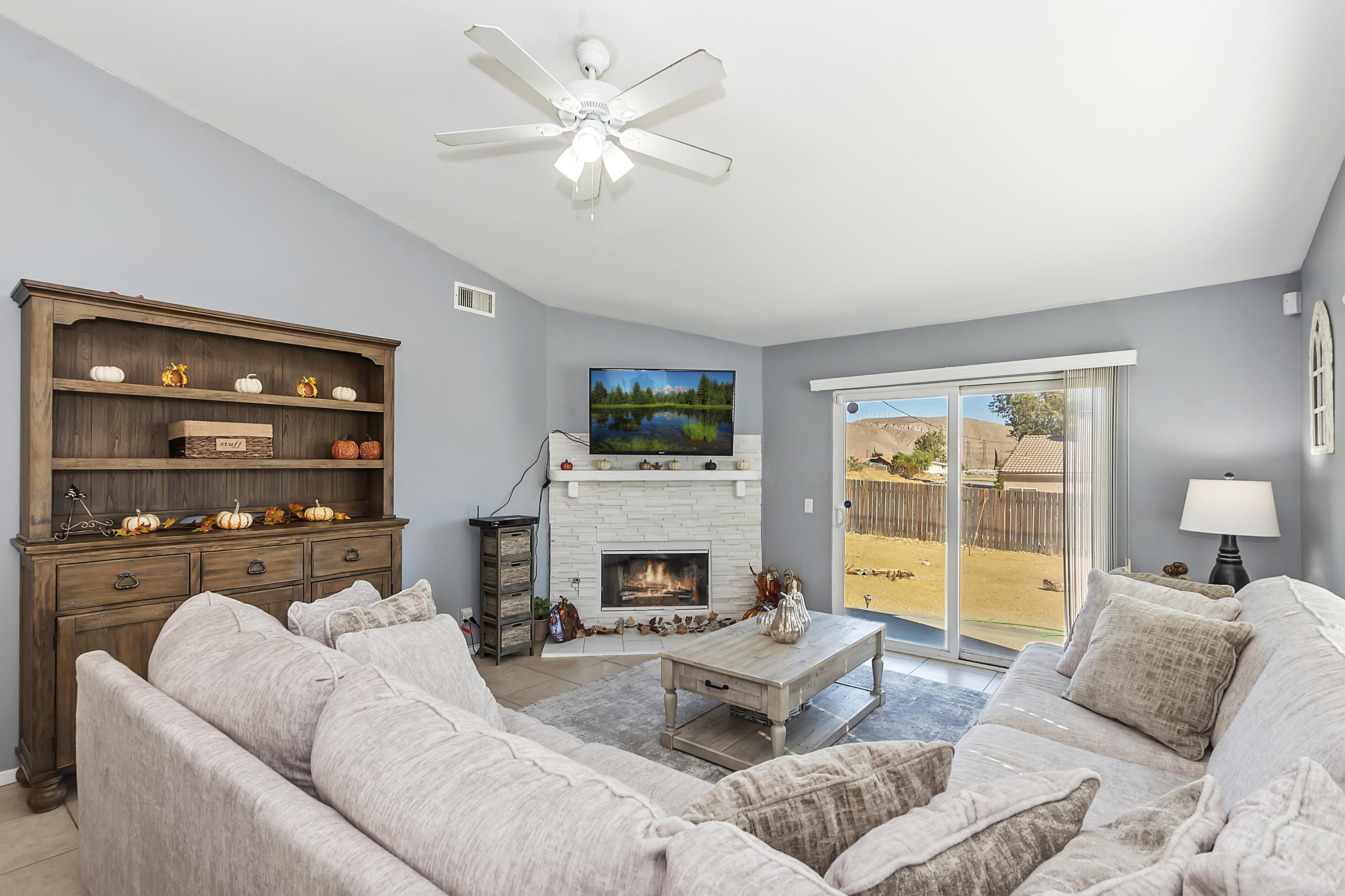 13140 Zane Way Whitewater, CA 92282 - Photo 6 of 25 a living room with furniture a fireplace and a flat screen tv
