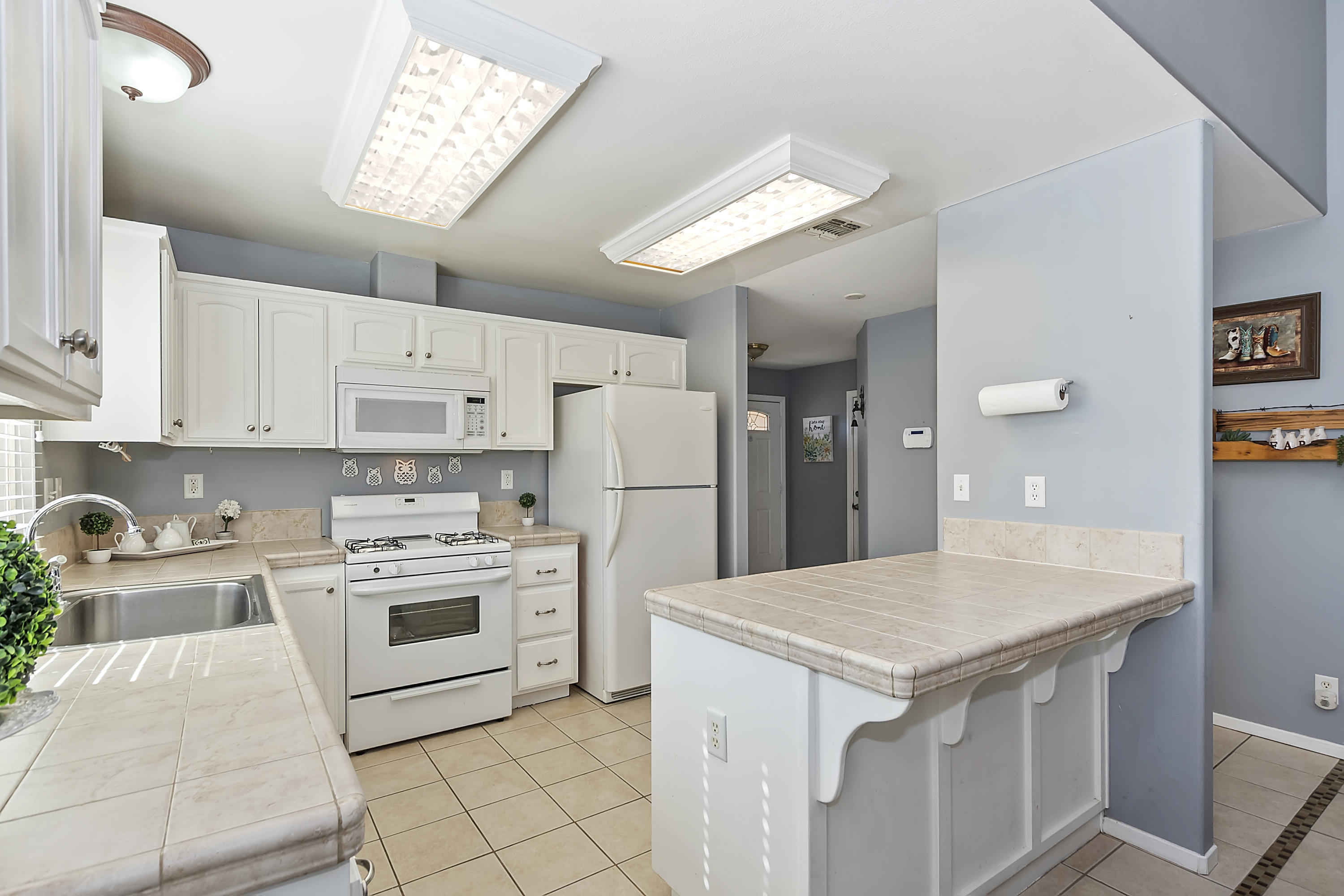13140 Zane Way Whitewater, CA 92282 - Photo 10 of 25 a kitchen that has a lot of white cabinets and stainless steel appliances