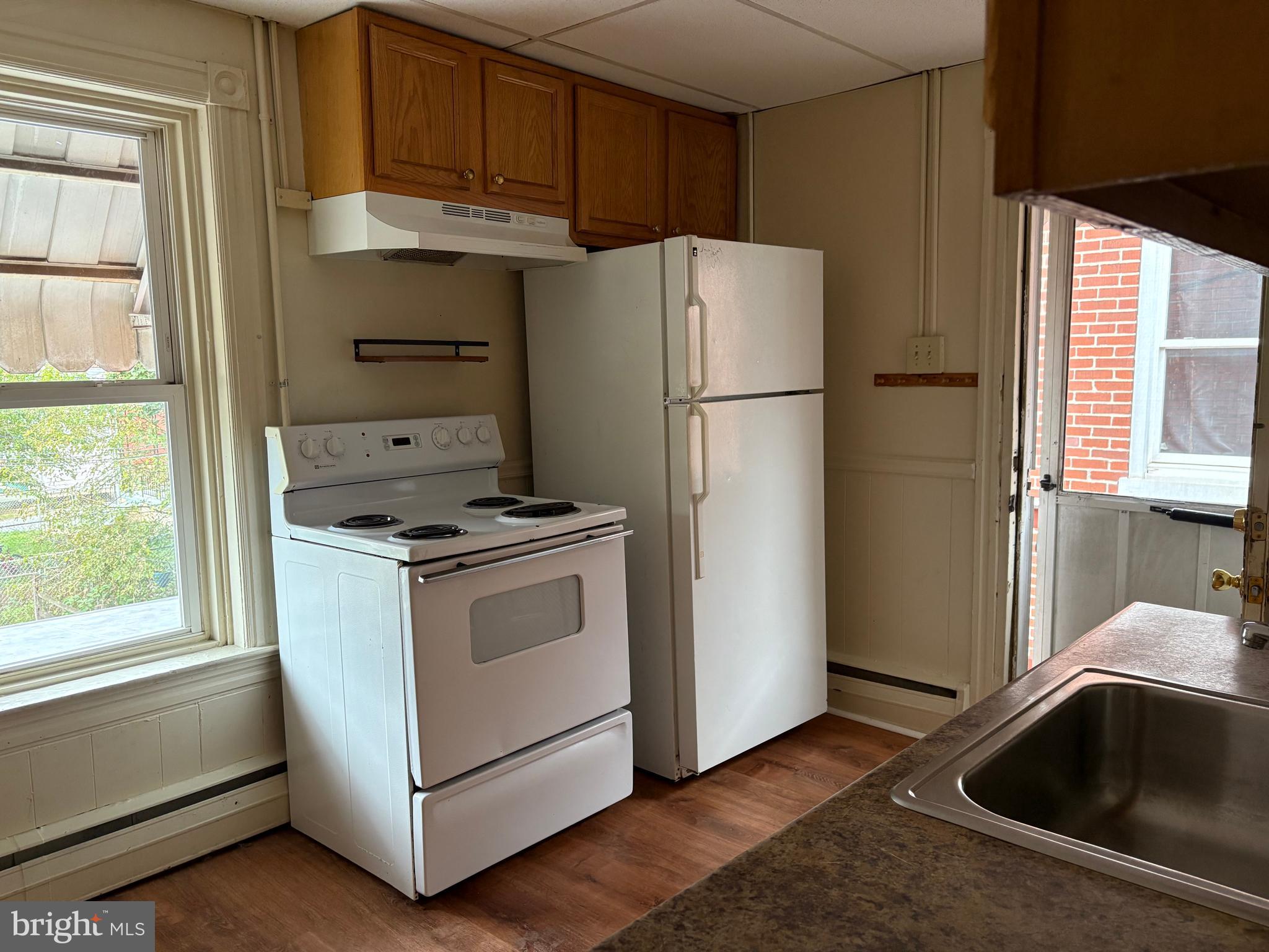 114 Strode Avenue Coatesville, PA 19320 - Photo 8 of 16 a kitchen with a refrigerator and white cabinets