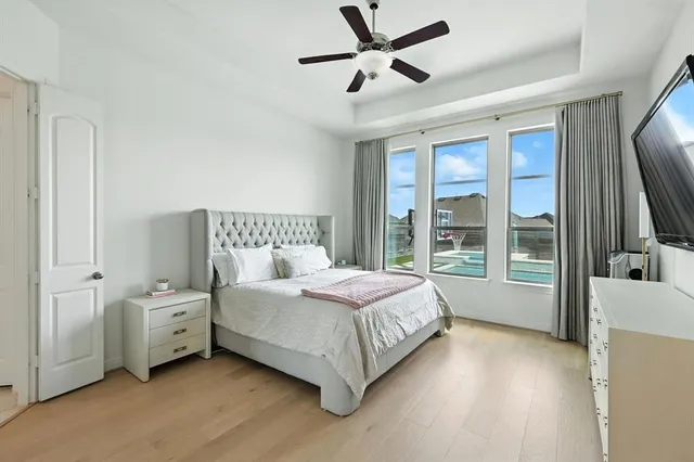 a spacious bedroom with a bed a couch and a flat tv screen