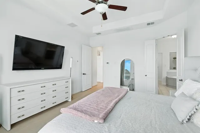 a bedroom with a bed a flat screen tv and dresser