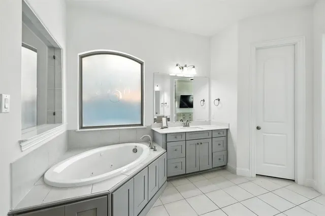 a bathroom with a bathtub sink and mirror