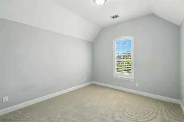 a spacious bedroom with a bed and a dresser