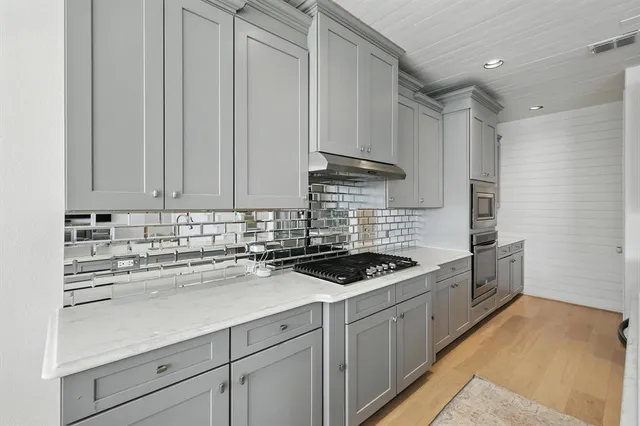 a kitchen with granite countertop a sink a stove and cabinets