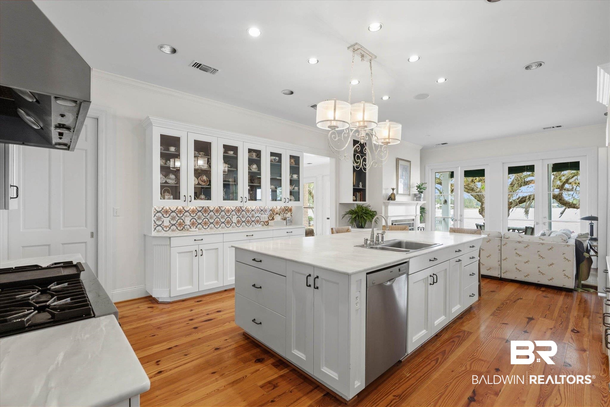 3500 Higgins Road Mobile, AL 36619 - Photo 12 of 54 Kitchen featuring white cabinets, a center island with sink, light wood-type flooring, and ornamental molding