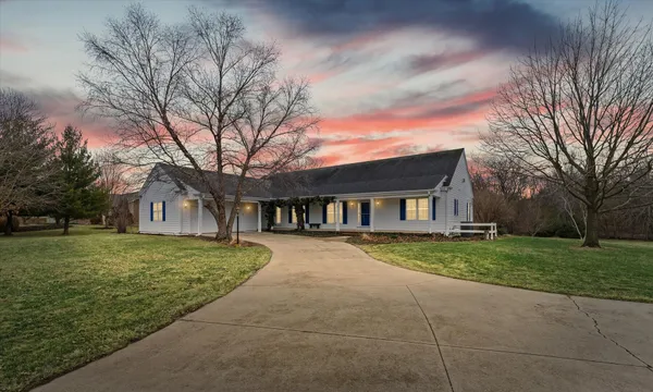 a front view of a house with a yard and trees
