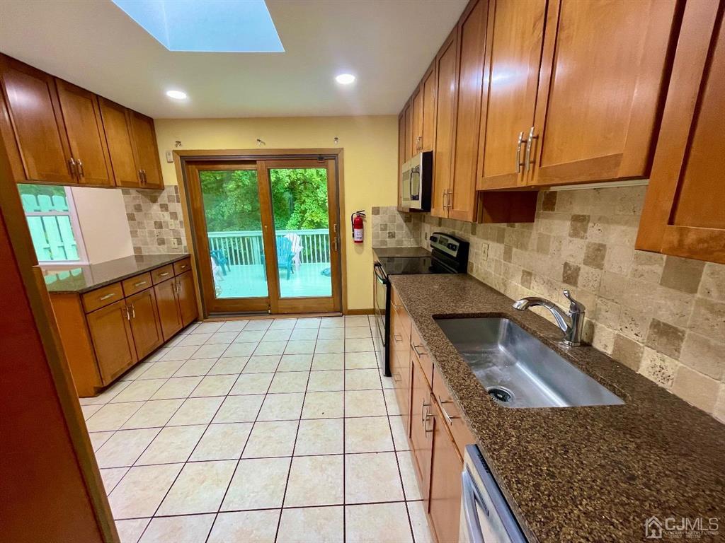 5 Greenwich Road Edison, NJ 08820 - Photo 8 of 52 a kitchen with stainless steel appliances granite countertop a stove a sink and a microwave