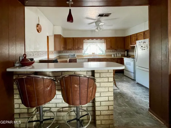 a kitchen with stainless steel appliances granite countertop a sink a stove and chairs