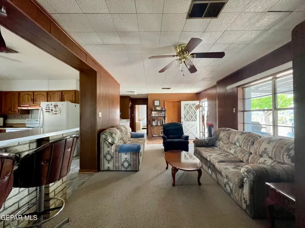 a living room with furniture a chandelier and a large window
