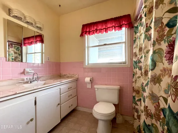a bathroom with a toilet sink vanity and mirror