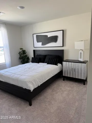 a bedroom with a bed and a potted plant